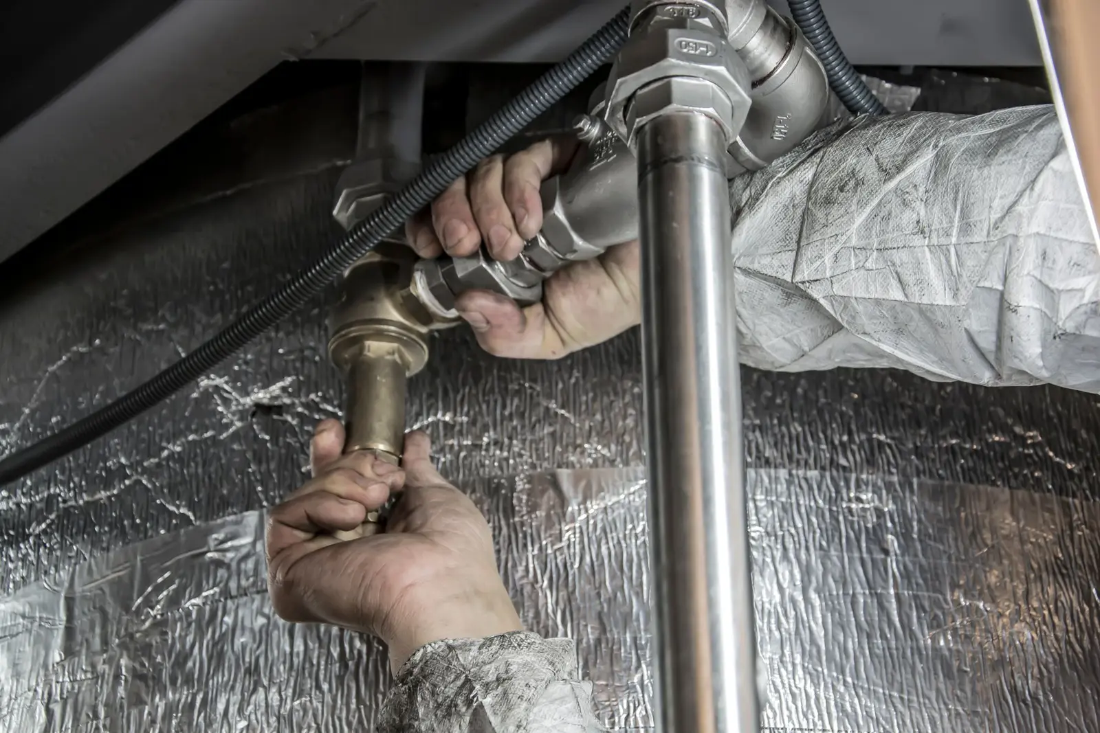 Plumber fitting commercial pipework in a mechanical space